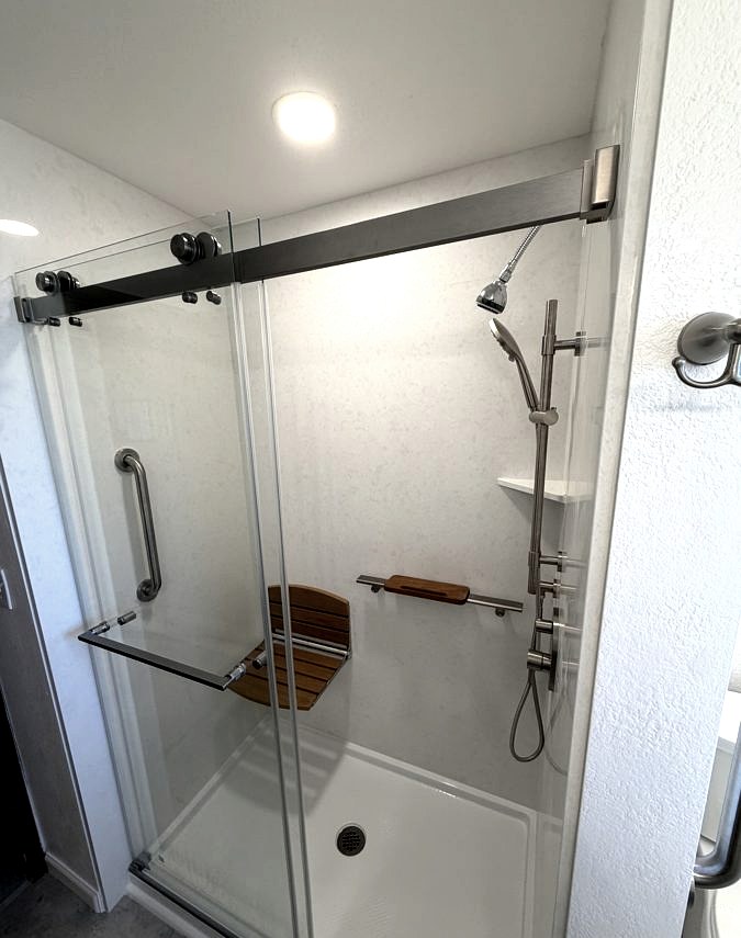 Walk-in shower with teak bench and brushed hardware